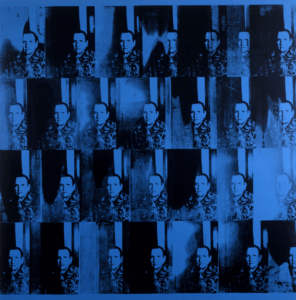 A grid of repeated images in blue and black tones depicting a figure resembling Gertrude Stein. The image is arranged in a repetitive pattern, with each square featuring the same portrait but varying slightly in clarity and contrast. The entire piece features hues of black and blue.